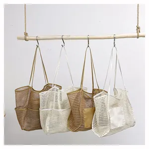 Detalle de cuatro bolsos de playa de malla tejida colgados en un poste de madera