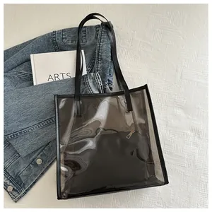 Detail view of black transparent PVC tote bag with matching inner pouch and gold zipper