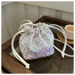 Detailed top view of a white iridescent sequin bucket bag with drawstring closure