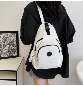 Detail view of white nylon chest bag with black zipper contrast and round sport logo