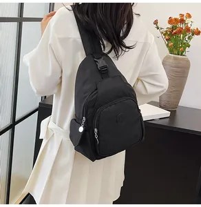 Detailed shot of a black minimalist chest bag with multi-pocket design and adjustable strap buckle