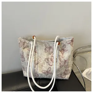 Macro view of plush butterfly jacquard texture and resin buckle on cream tote bag
