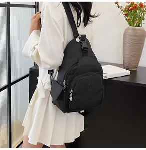 Model view of black nylon chest bag with adjustable strap and multiple zipper compartments