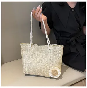 Détail du sac cabas en paille avec poignée en corde blanche et un petit décor de marguerite