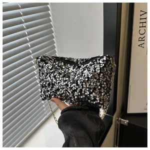 Detailansicht der glitzernden Pailletten und der goldenen Kette dieser schwarzen Abendtasche