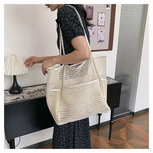 Detalle del bolso de playa de malla beige con gran capacidad y prácticos bolsillos externos