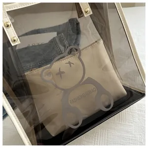 Detailed macro view of clear PVC tote bag featuring cream leather trim and gold studs