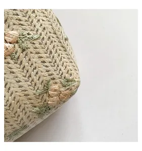 Detail of floral embroidery on a woven bag with delicate mesh layer and 3D roses