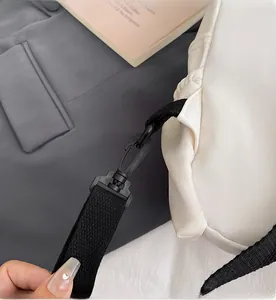 Close-up of a durable black plastic quick-release hook and woven strap on a chest bag