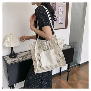 Detalle del bolso de malla beige que muestra la textura tejida y las correas largas de hombro