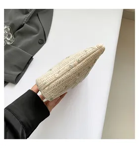 Detailed close-up of floral embroidery on beige woven straw handbag for women