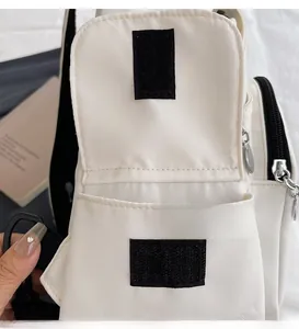 Detail of front flap pocket with black velcro closure on cream nylon chest bag