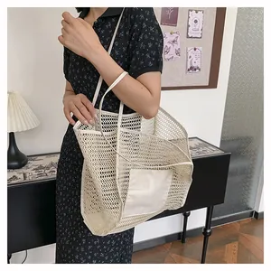 Primer plano del bolso tote de malla blanca con bolsillo de lona y asas largas