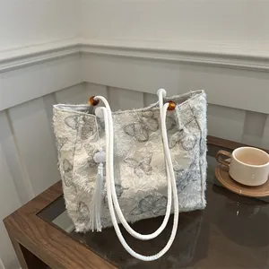 White butterfly tote bag with feather fringe texture and elegant amber bead details