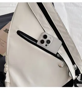 Detail of rear anti-theft zipper pocket on cream nylon chest bag with phone storage