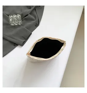 Macro detail of high-quality golden zipper and delicate floral embroidery on small bag