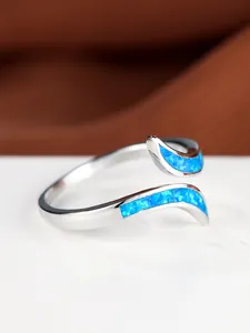 Close-up of a silver-toned wave ring featuring vibrant blue opal inlay detail