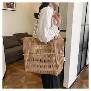 Detalle de bolsa de playa de malla marrón claro con gran capacidad y bolsillo lateral