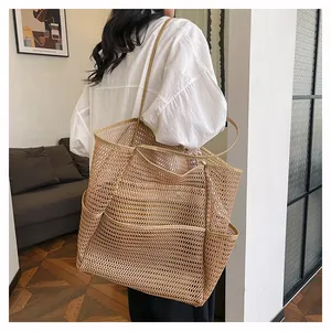Vista detallada de un bolso tote de malla beige al hombro ideal para la playa y el diario