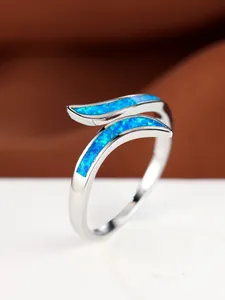 Detailed macro view of white gold plated ring with blue opal inlay in a wavy design