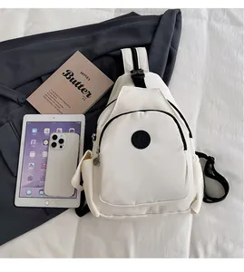 Detailed top view of white nylon sling bag showing daily capacity with tablet and phone