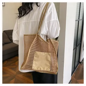 Detalle del bolso tote de malla tejida caqui con bolsillo de tela y correas largas al hombro