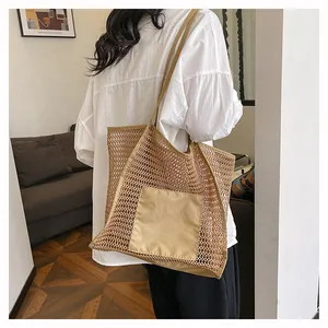 Vista detallada del bolso de hombro de malla marrón con bolsillo en una modelo