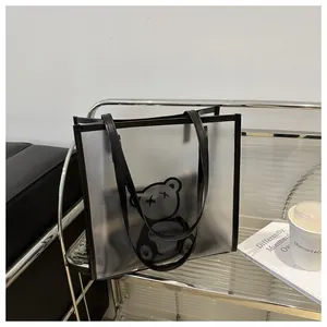 Detail view of the large PVC jelly tote bag with cartoon bear print and black handles