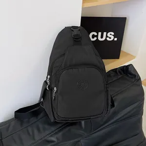 Minimalist black multi-pocket nylon chest bag with adjustable strap and sport emblem
