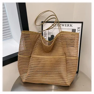 Detalle de bolso tote de malla caqui con bolsillos laterales sobre mesa de metal