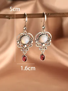Detail view of vintage silver earrings with opal and red gemstone, size 5cm by 1.6cm