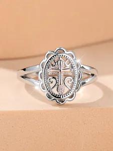 Close-up of vintage hollow lace ring with rose gold cross and scroll patterns