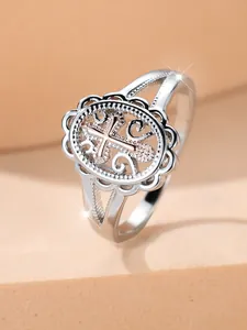 Macro detail of vintage hollow lace ring with rose gold cross and silver finish