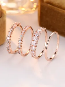 Close-up of four-piece rose gold ring set with cubic zirconia on brown velvet
