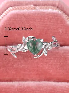 Macro detail of heart-shaped moss agate ring with sterling silver vine band design