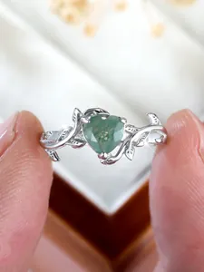 Macro detail of leaf-vine silver band featuring a heart-shaped green moss agate stone