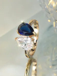 Vue macro de la bague Toi et Moi dorée avec zircones poires bleues et transparentes