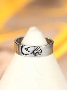 Dettaglio macro dell'anello d'argento lucido con lettera A incisa e motivo a promessa