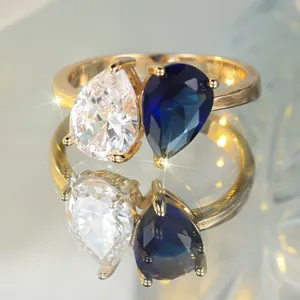 Bague dorée avec pierres blanches et bleues en forme de poire en vue centrale