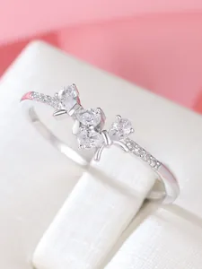 Close-up of S925 sterling silver bow ring with sparkling pear-cut crystals on a box
