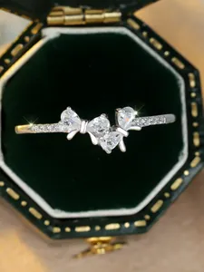 Macro shot of S925 silver bow ring with sparkling crystals on a velvet box