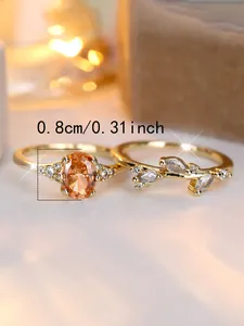 Detailed macro view of a gold-plated ring set with an orange zircon and leaf patterns