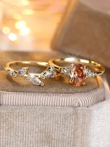 Macro shot of gold tone oval orange gemstone and marquise leaf ring set detail