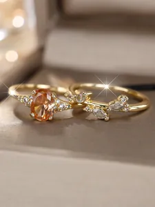 Macro view of gold-plated leaf ring set with amber oval stone and marquise crystals