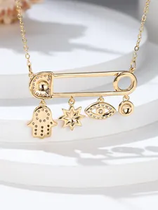 Detail of gold safety pin necklace featuring Hamsa, Evil Eye and star charm pendants