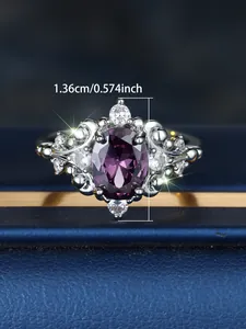 Macro shot of oval purple gemstone ring with diamond halo on dark blue jewelry box