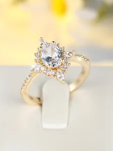 Makroaufnahme eines goldenen Sonnenstrahlenrings mit ovalem Zirkon und strahlendem Halo
