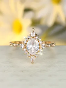 Nahaufnahme eines Vintage-Goldrings mit großem ovalem Zirkonia und floralem Halo