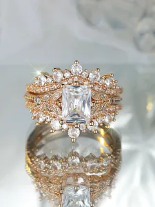 Detalle macro de un set de anillos en oro rosa con cristal talla esmeralda y pavé