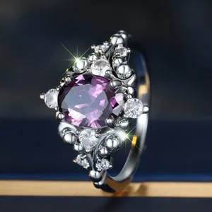 Elegant silver ring featuring a large oval purple gemstone surrounded by sparkling white diamonds